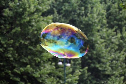 Giant soap bubbles created with ropes and sticks in a park