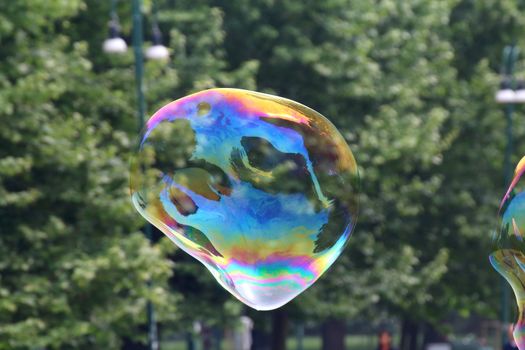 Giant soap bubbles created with ropes and sticks in a park