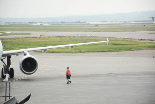Airport worker attends docked airplane