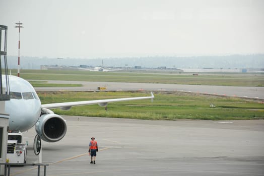 Airport worker attends a passenger plane