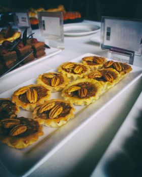 Photograph of a nut pie dessert on a table with other pies