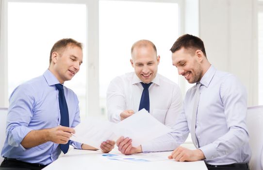 business and office concept - smiling businessmen with papers in office