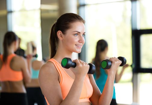 fitness, sport, training and lifestyle concept - group of women with dumbbells in gym