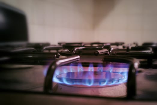 Photograph of a lighted metal gas stove and blue fire flame