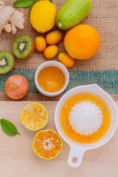 Freshly orange juice with orange slice, ginger , passion fruit ,honey ,kiwi set up on wooden table .