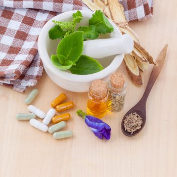 Alternative health care fresh herbal  ,dry and herbal capsule with mortar on wooden background.
