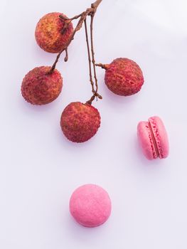 Brunch of ripe lychee and lychee macaroons with leaf isolate on white background.