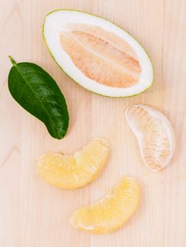 Fresh pomelo cutting and peeled on the wooden background.