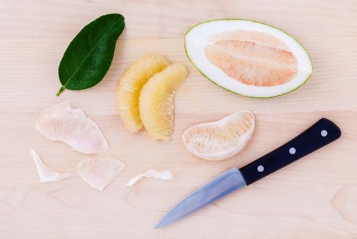 Fresh pomelo cutting and peeled on the wooden background.