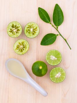 Fresh Lime juice and lime slice on wooden background with lime leaf.
