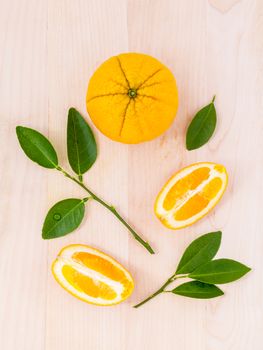 Fresh oranges and orange slice on wooden background with orange leaf.