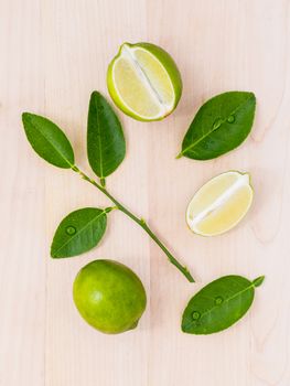 Fresh lime and lime slice on wooden background with  lime leaf.
