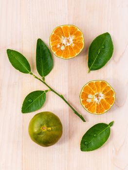 Fresh oranges and orange slice on wooden background with orange leaf.