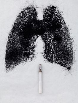 Shape of lungs with charcoal powder and cigarette on white background 