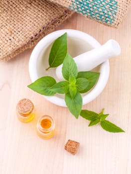 Alternative medicine lemon basil oil natural spas ingredients for aroma aromatherapy with mortar on wooden background.