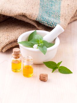 Alternative medicine lemon basil oil natural spas ingredients for aroma aromatherapy with mortar on wooden background.