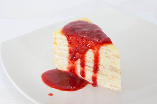 Crepe Cake with strawberry source on dish