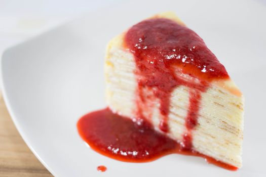 Crepe Cake with strawberry source on dish