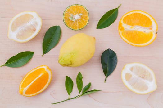 Mixed citruses fruit oranges, lemon on wooden background with orange leaf.