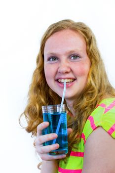 Caucasian teenage girl drinking blue soft drink with straw isolated on white background
