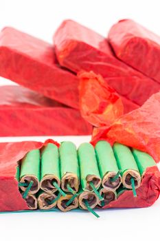 Red packets with stack of green firecrackers isolated on white background