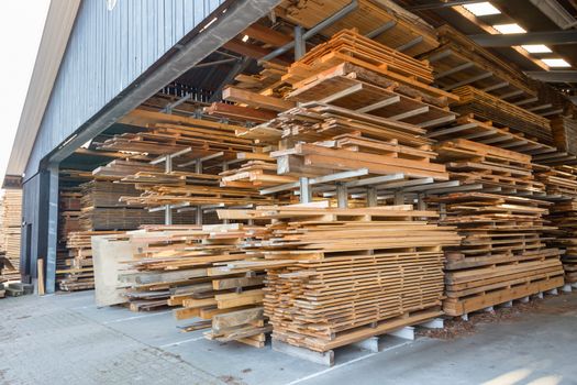 Stacks of wooden planks in barn for storage and sale