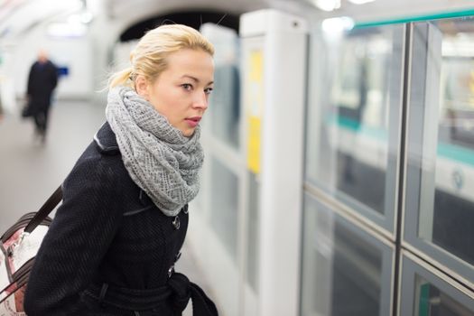 Young woman  waiting on the platform of a subway station for their metro to arrive.