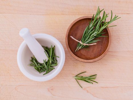 Fresh rosemary herbal medicine in mortar and wooden bowl on wooden table