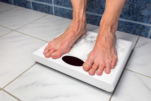 Female feet standing on bathroom scales for measuring body weight