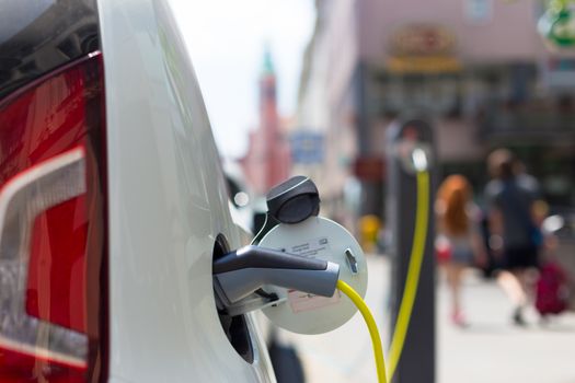 Power supply for electric car charging.  Electric car charging station. Close up of the power supply plugged into an electric car being charged.