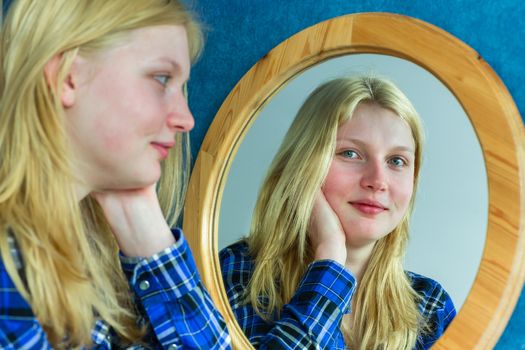 Blonde teenage dutch girl looking in mirror