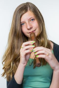 Blonde caucasian teenage girl playing the flute isolated on white background