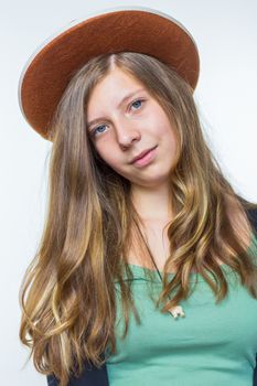 Blonde european teenage girl with long blonde hair wearing brown hat isolated on white background