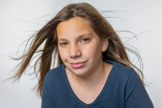 Caucasian teenage girl with long blown hair isolated on white background