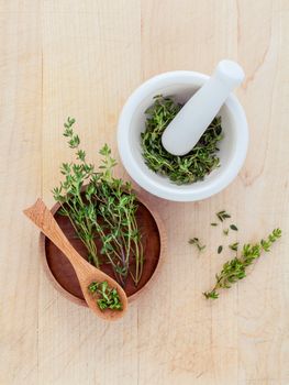 Bunch of fresh organic thyme in white mortar on wooden background