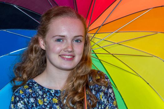 Blonde dutch teenage girl under umbrella with various colours