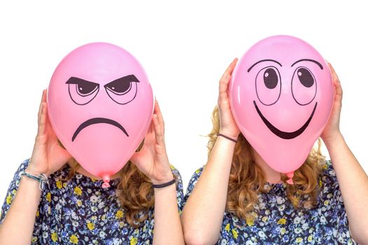 Two girls holding pink balloons with facial expressions of frustrated and smiling face isolated on white background