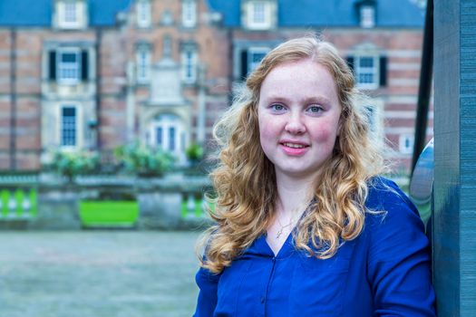 Portrait of european red haired teenage girl with castle on background