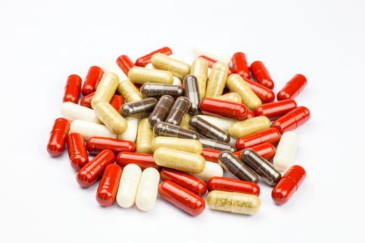 Pile of red brown and white medical capsules against disease for health, isolated on white background