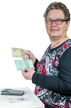 Senior caucasian  woman counting and showing money with calculator isolated on white background