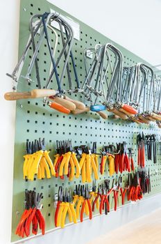 Pliers and other tools hanging on wall in classroom on high school