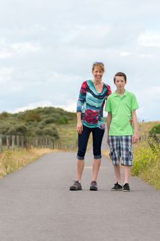 Caucasian mother and son hiking on footpath in nature