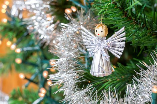 Little angel from heaven hanging in Christmas tree as decoration