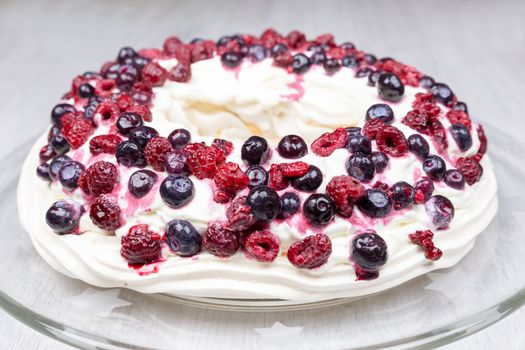 Raspberries and blueberries foam pie as food on glass scale