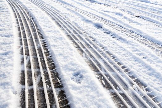 Car tire tracks in snow symbol of transport during winter season