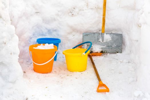 Hut with walls of snow and colourful buckets plus snowplow