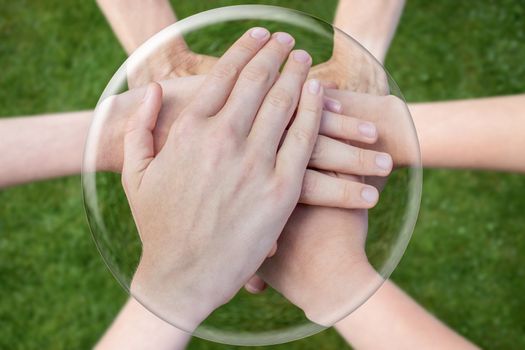 Hands arms above grass uniting joining in glass sphere