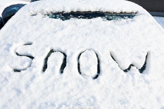 Word snow on windshield of car in winter season