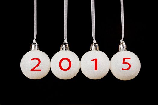 Four white christmas balls with old year 2015 isolated on black background