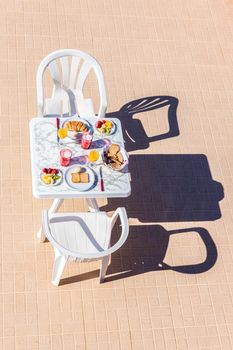 Food for breakfast on table with two chairs at terrace